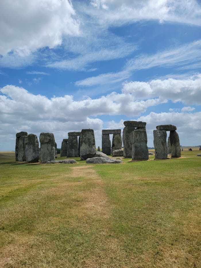 Capture of the iconic Stonehenge in England against a backdrop of blue sky and clouds.